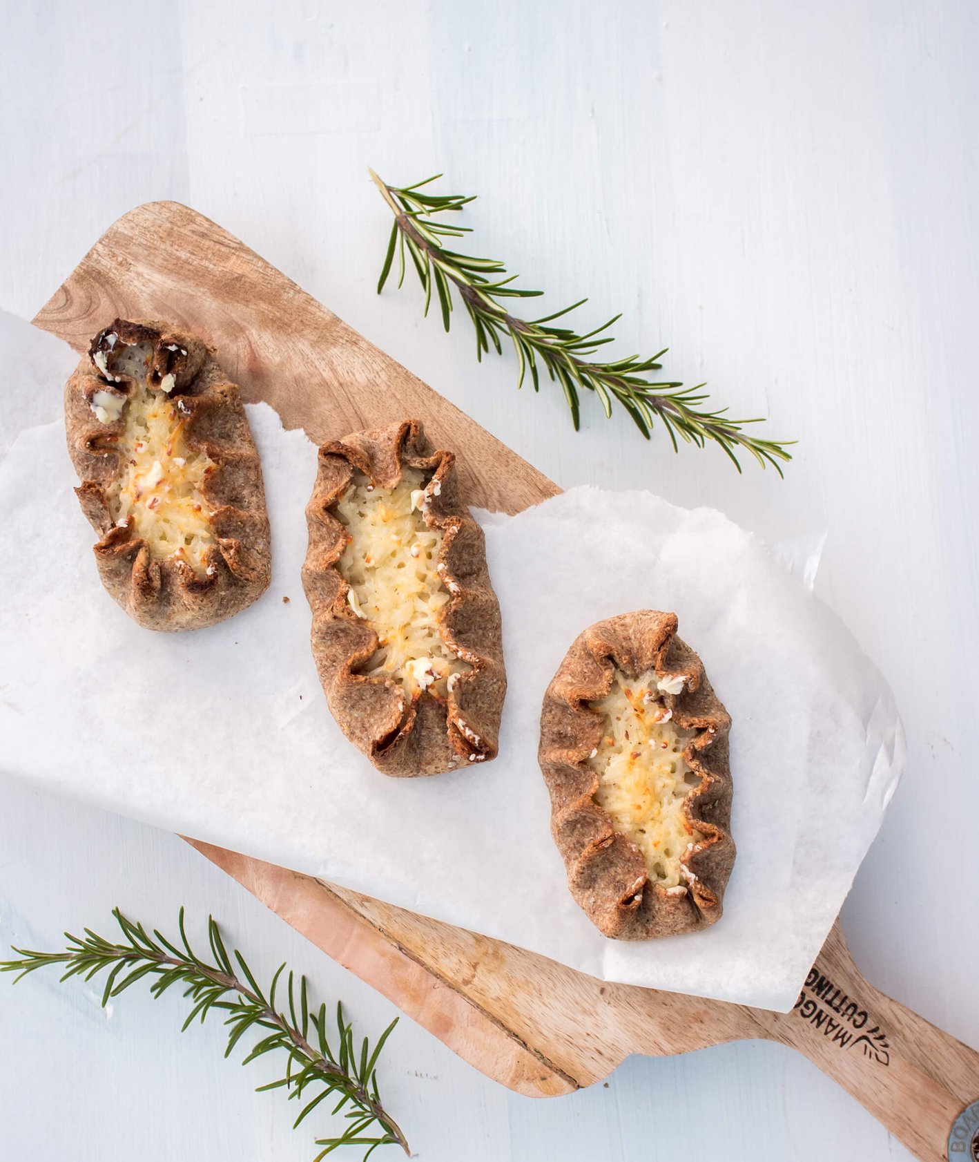 Fińskie pierogi karelskie – Karjalanpiirakka, upieczone w piekarniku, polane roztopionym masłem